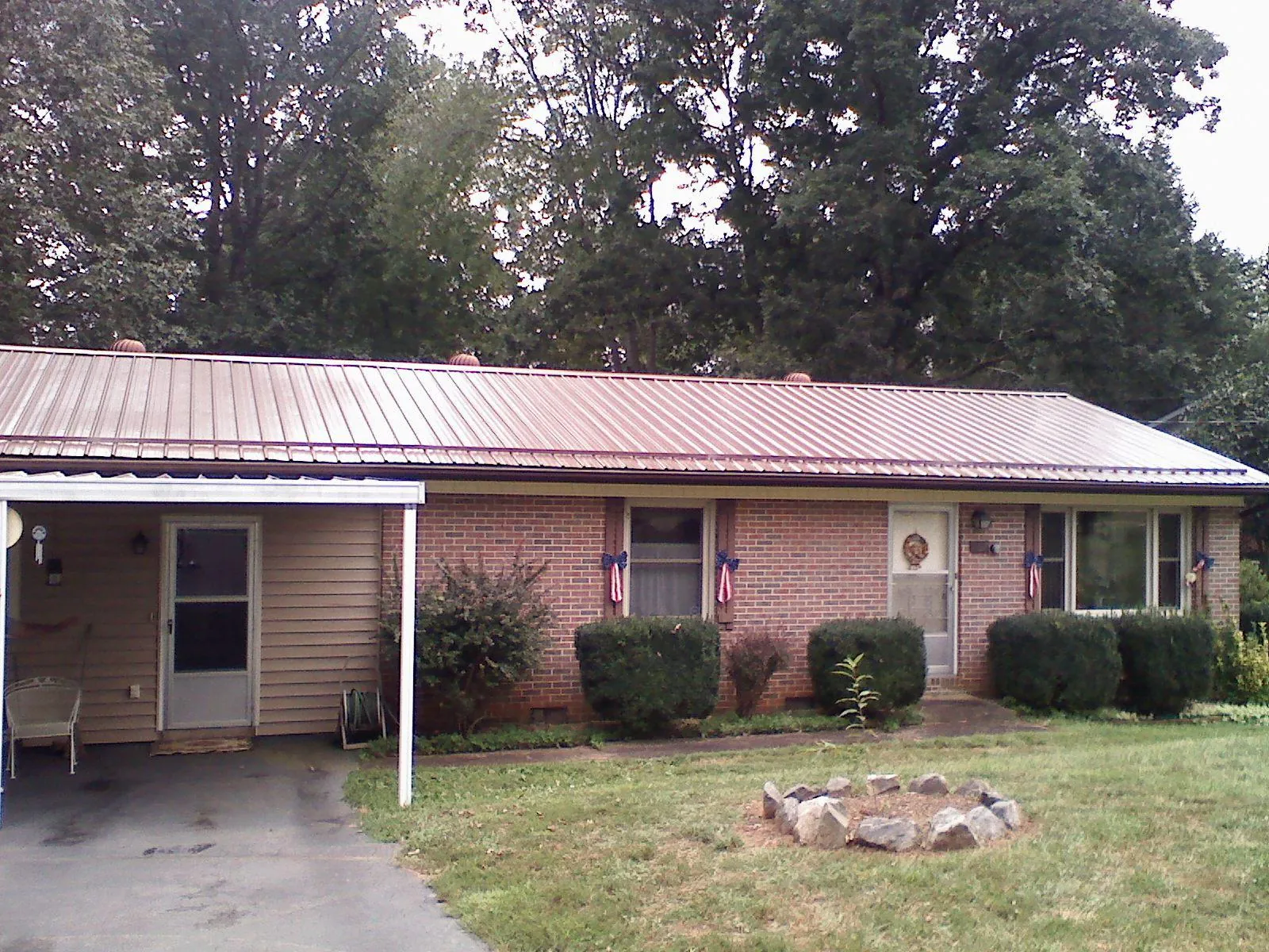 Bronze metal roof and carport on a brick ranch home — Roof Repair work by our crew in Crandall