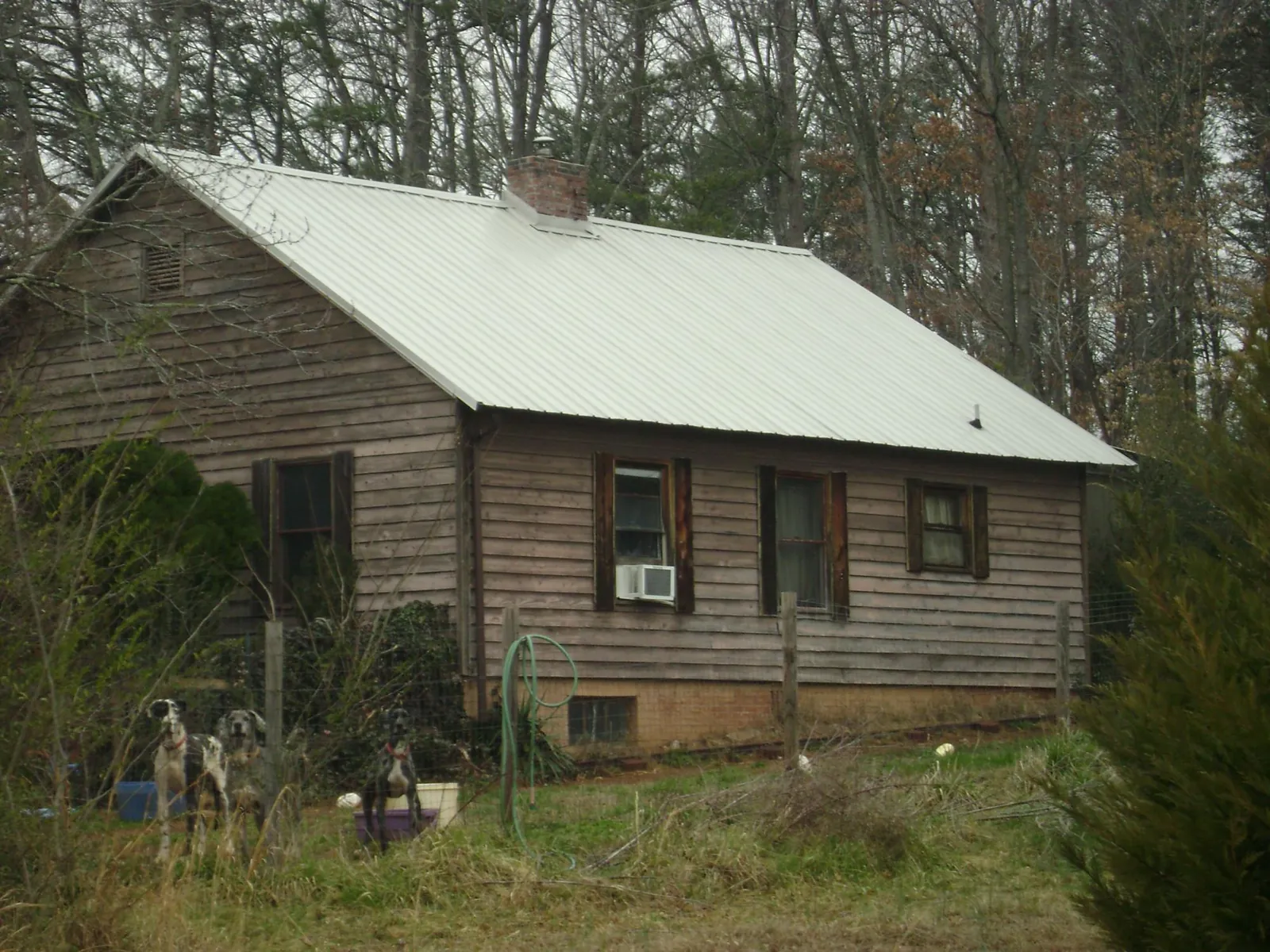 White metal roof on an old wood sided farmhouse, from a Metal Roof Installation job in Crandall